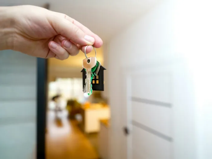 Property manager handing over house keys at a front door