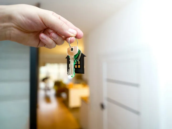 Property manager handing over house keys at a front door